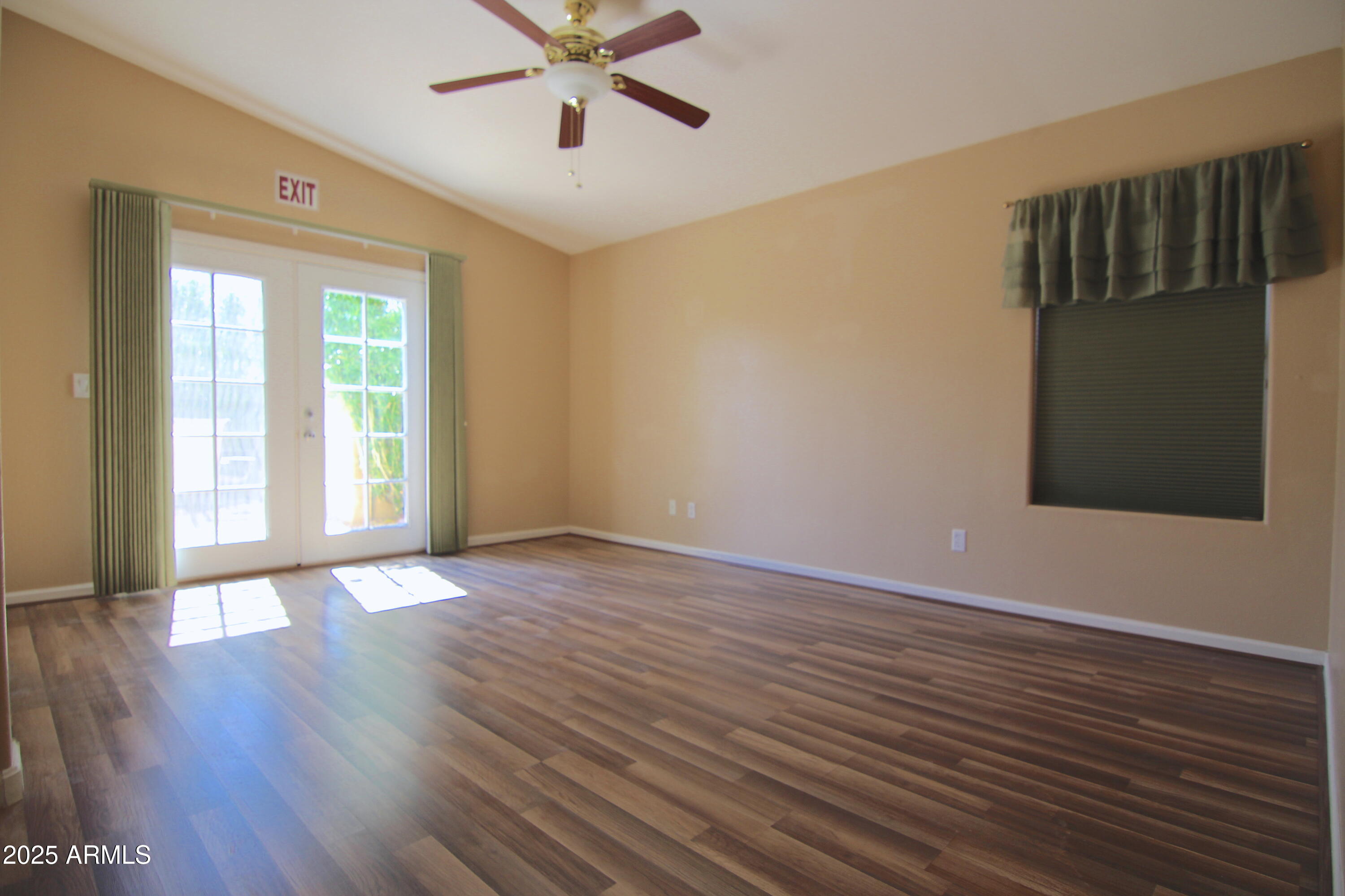 3569 East Utopia Road Phoenix, AZ 85050 - Photo 3 of 16 a view of an empty room with wooden floor and a window