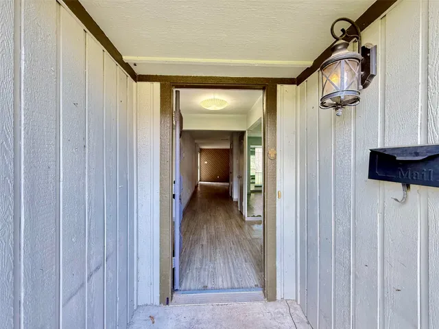 a view of a hallway with wooden floor and stairs