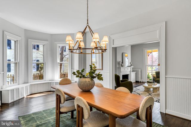 a kitchen with stainless steel appliances kitchen island granite countertop a refrigerator a stove a sink dishwasher and white cabinets with wooden floor