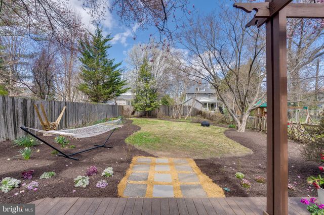 a view of a patio with table and chairs potted plants and large tree