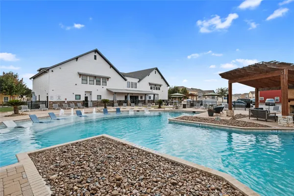 a view of a house with pool and chairs