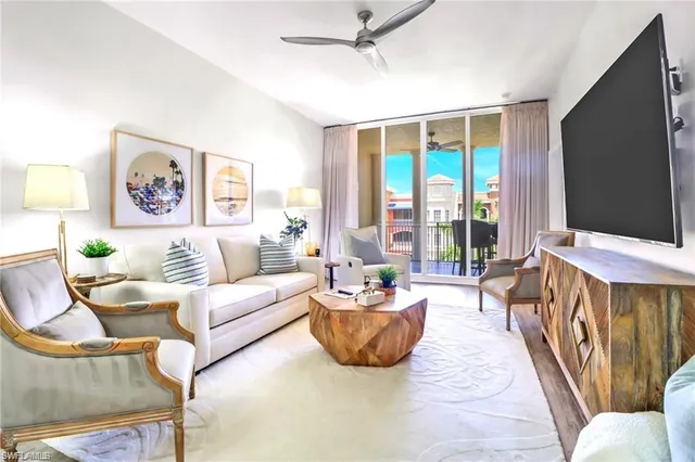 a living room with furniture a flat screen tv and a large window