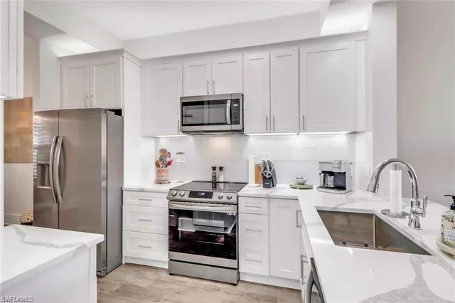 a kitchen with stainless steel appliances a stove a sink a refrigerator and cabinets
