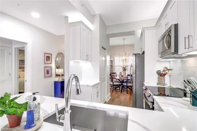 a living room with furniture a potted plant and a large window