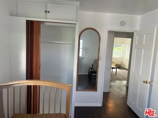 a view of hallway with livingroom and wooden floor