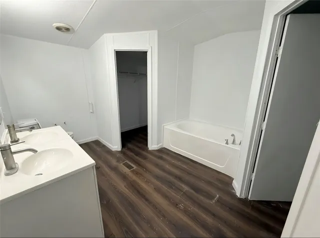 a bathroom with a tub sink and a mirror