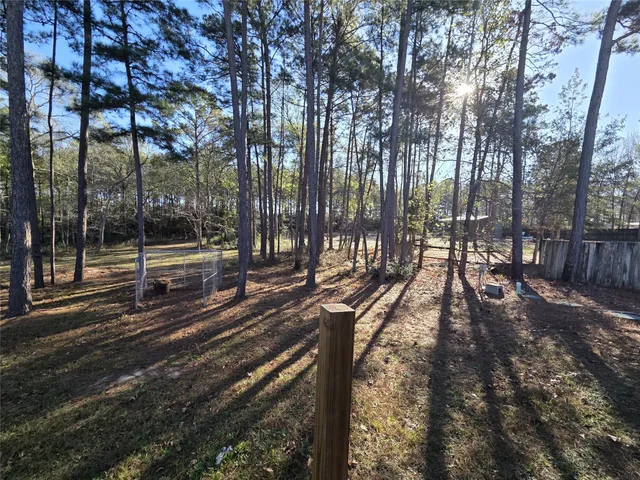 a view of a yard with wooden fence