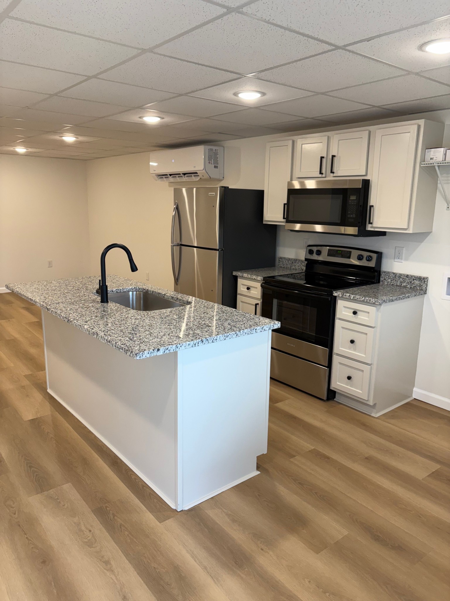 606 Dover Road, Unit 1 Clarksville, TN 37042 - Photo 2 of 12 a kitchen with kitchen island granite countertop a stove top oven a sink dishwasher and white cabinets with wooden floor