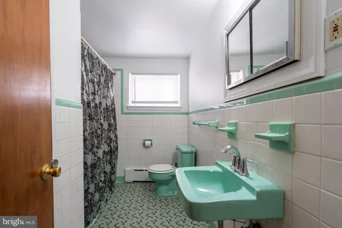 a bathroom with a sink toilet and mirror
