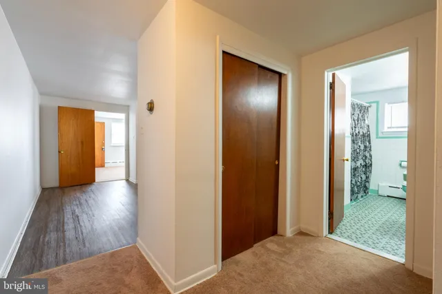 a view of hallway with bathroom and wooden floor
