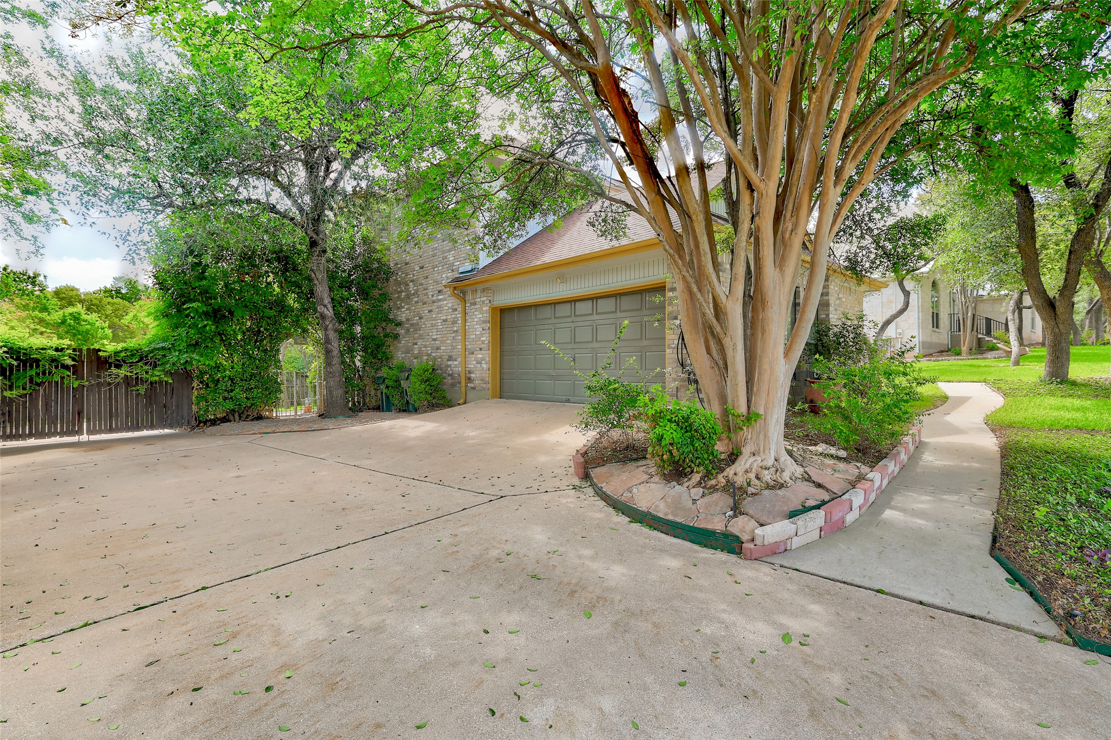 110 South Ridge Circle Georgetown, TX 78628 - Photo 28 of 37 Expansive concrete driveway leading to a two-car garage with a panel door