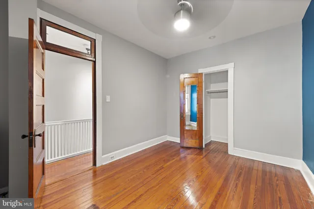 an empty room with wooden floor and closet