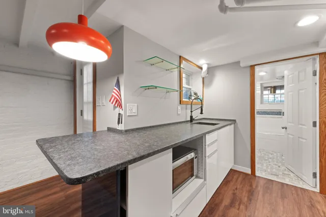 a kitchen with stainless steel appliances granite countertop a sink cabinets and wooden floor