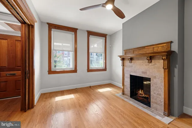 an empty room with windows fireplace and wooden floor
