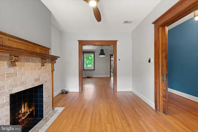 a view of a livingroom with wooden floor and a fireplace