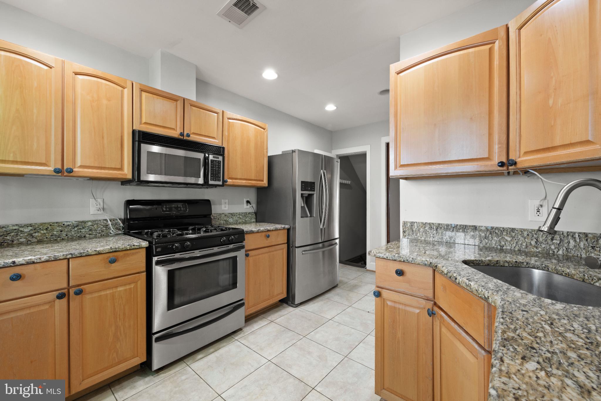 445 Newton Place Northwest Washington, DC 20010 - Photo 9 of 26 a kitchen with stainless steel appliances granite countertop a stove a sink and a microwave