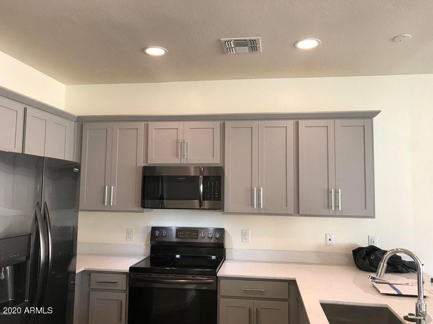 4038 East Erie Street, Unit 101 Gilbert, AZ 85295 - Photo 3 of 7 a kitchen with stainless steel appliances a refrigerator a stove a microwave and sink