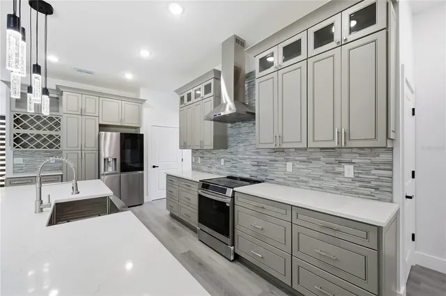 a view of an empty room with wooden floor and a ceiling fan