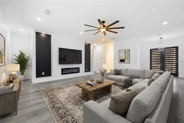 a view of a room with wooden floor and a ceiling fan