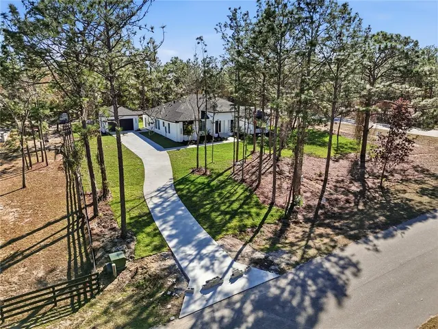 a view of a house with a yard and tree s