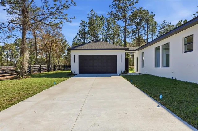 a front view of a house with a garden and plants