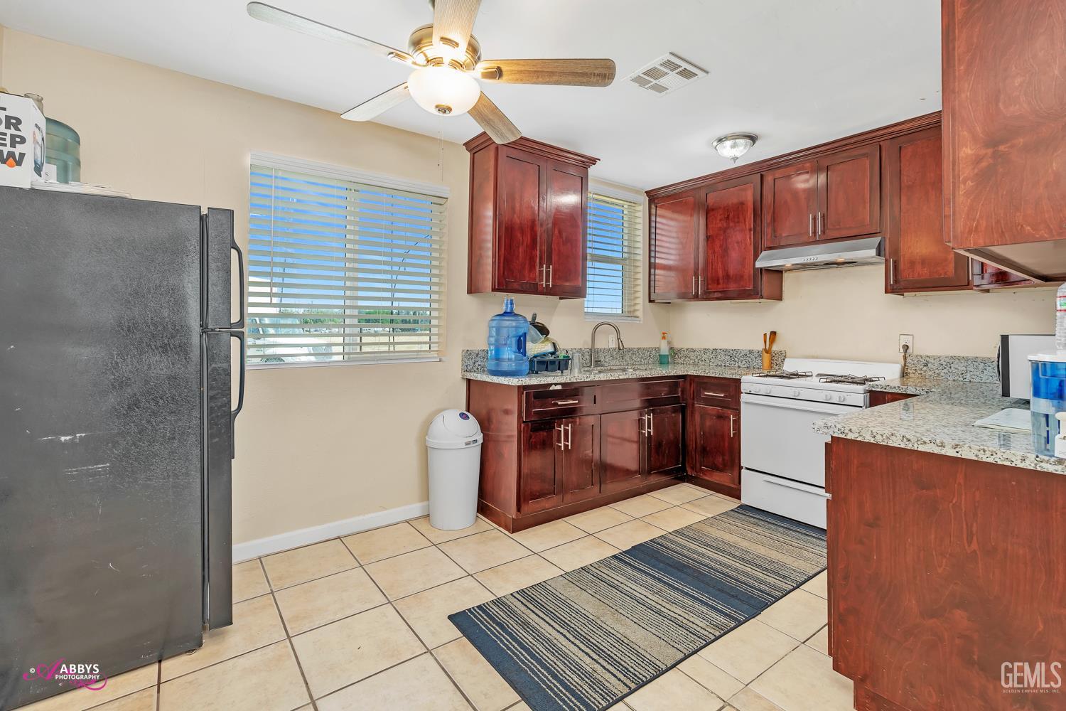Undisclosed Address Bakersfield, CA 93307 - Photo 46 of 62 a kitchen with stainless steel appliances granite countertop a stove a sink dishwasher and a refrigerator