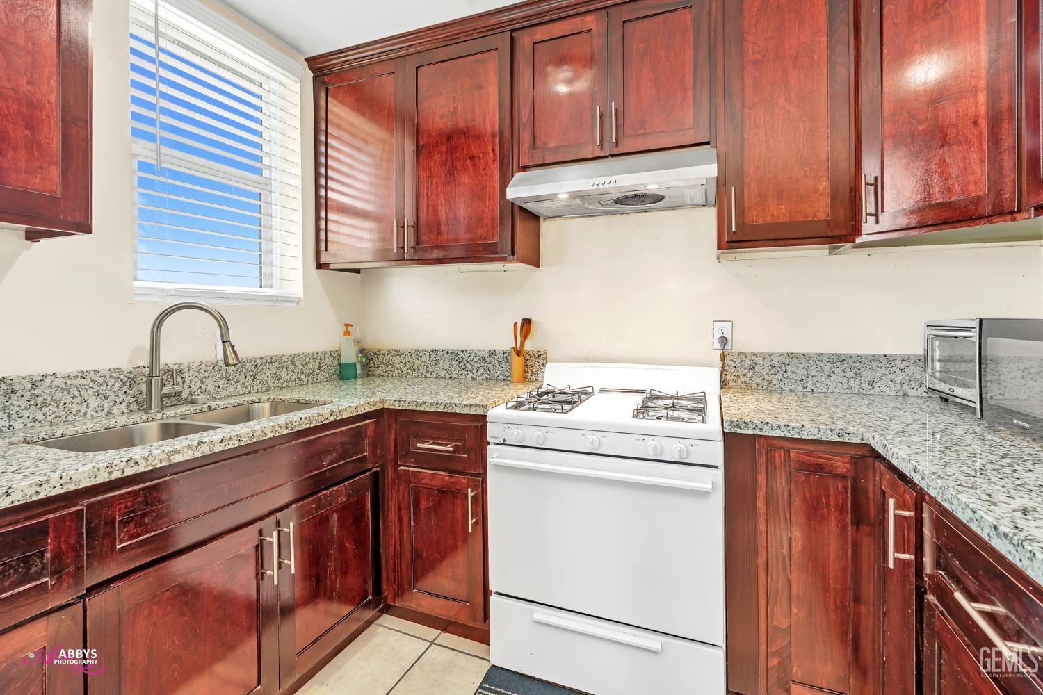 Undisclosed Address Bakersfield, CA 93307 - Photo 49 of 62 a kitchen with stainless steel appliances granite countertop a sink stove and cabinets