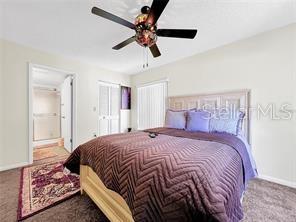 1337 Pine Ridge Circle East, Unit D2 Tarpon Springs, FL 34688 - Photo 13 of 17 a bedroom with a bed and a chandelier
