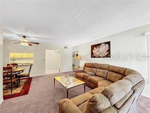 1337 Pine Ridge Circle East, Unit D2 Tarpon Springs, FL 34688 - Photo 4 of 17 a living room with furniture and a flat screen tv
