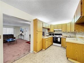 1337 Pine Ridge Circle East, Unit D2 Tarpon Springs, FL 34688 - Photo 8 of 17 a kitchen with stainless steel appliances granite countertop a refrigerator stove microwave and sink