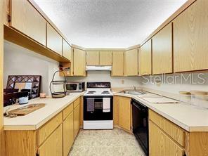 1337 Pine Ridge Circle East, Unit D2 Tarpon Springs, FL 34688 - Photo 9 of 17 a kitchen with stainless steel appliances granite countertop a sink stove and refrigerator