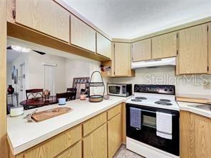 1337 Pine Ridge Circle East, Unit D2 Tarpon Springs, FL 34688 - Photo 10 of 17 a kitchen with stainless steel appliances a stove a sink and cabinets