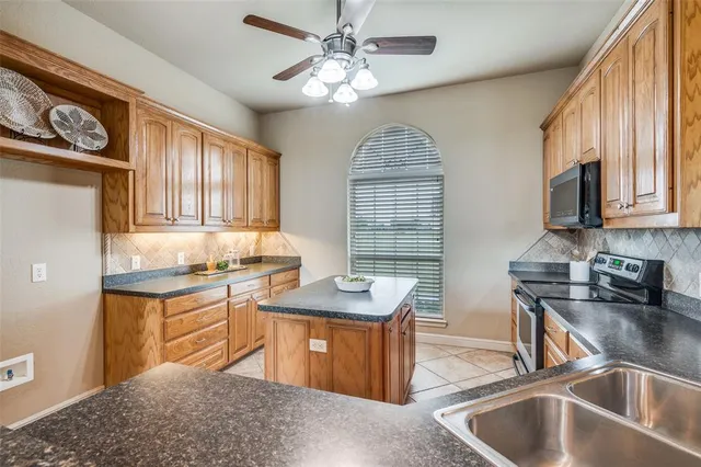 a kitchen with granite countertop a sink stove and cabinets