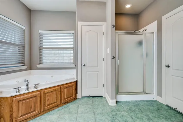 a bathroom with a tub sink vanity granite and a window