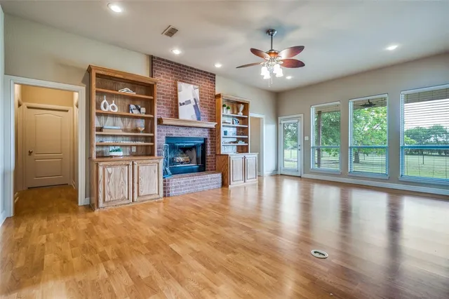 a view of an empty room with window and fire place