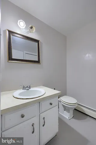 a bathroom with a toilet sink and mirror