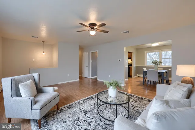 a living room with furniture and a view of kitchen