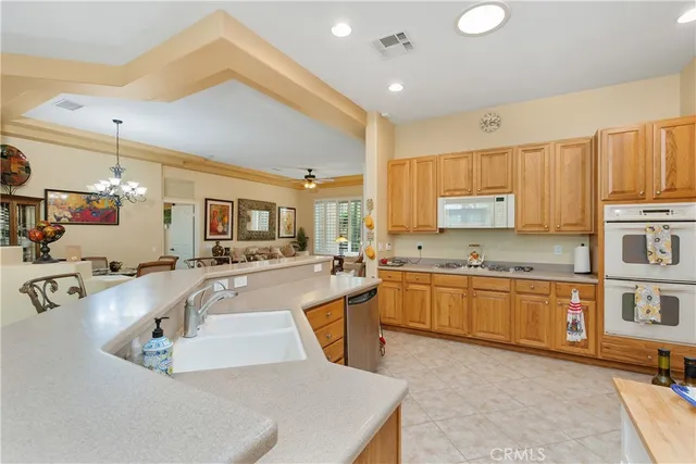 a large kitchen with kitchen island a large counter top space a sink stainless steel appliances and cabinets