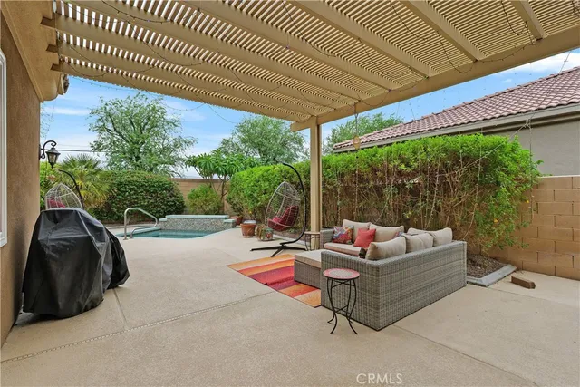 a living room with patio furniture and a floor to ceiling window