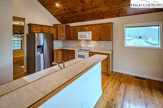 a kitchen with stainless steel appliances granite countertop a refrigerator and a stove top oven