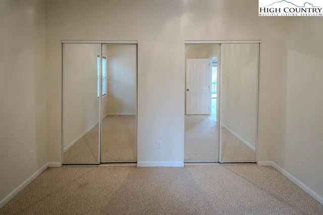 a view of an empty room with chandelier fan and a fireplace