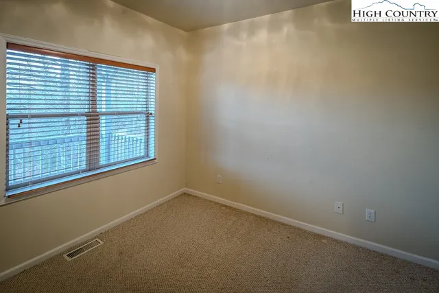 a view of an empty room with a fireplace and a window