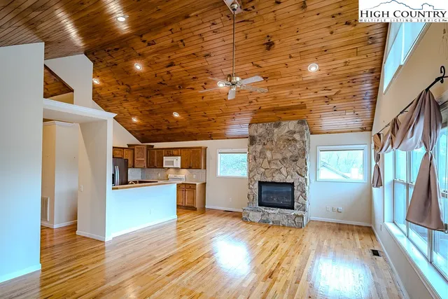 a view of a livingroom with wooden floor and a kitchen