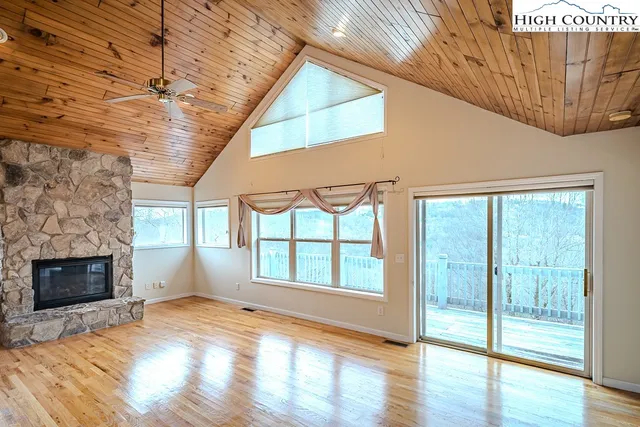 a view of empty room with wooden floor and fireplace