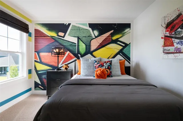 a bedroom with a bed and painting on the wall