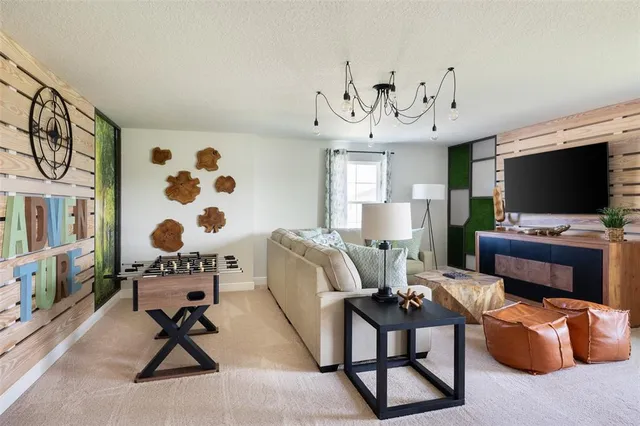 a living room with furniture a flat screen tv and kitchen view