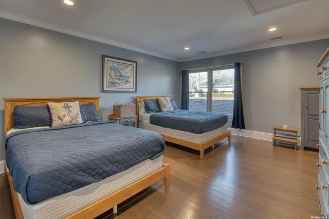 a bedroom with two beds and wooden floor