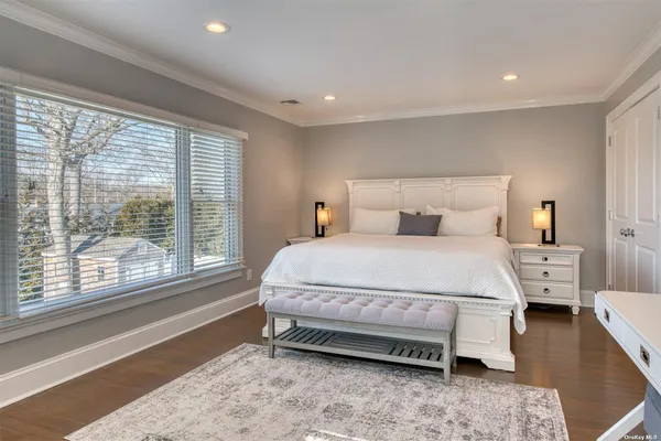 a bedroom with a bed and a large window