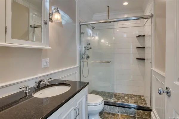 a bathroom with a granite countertop sink toilet and shower