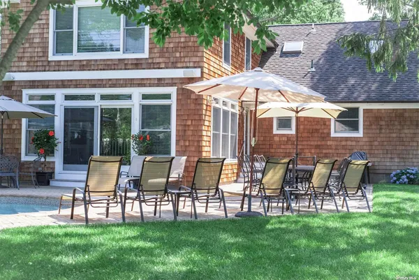 a patio with table and chairs and potted plants